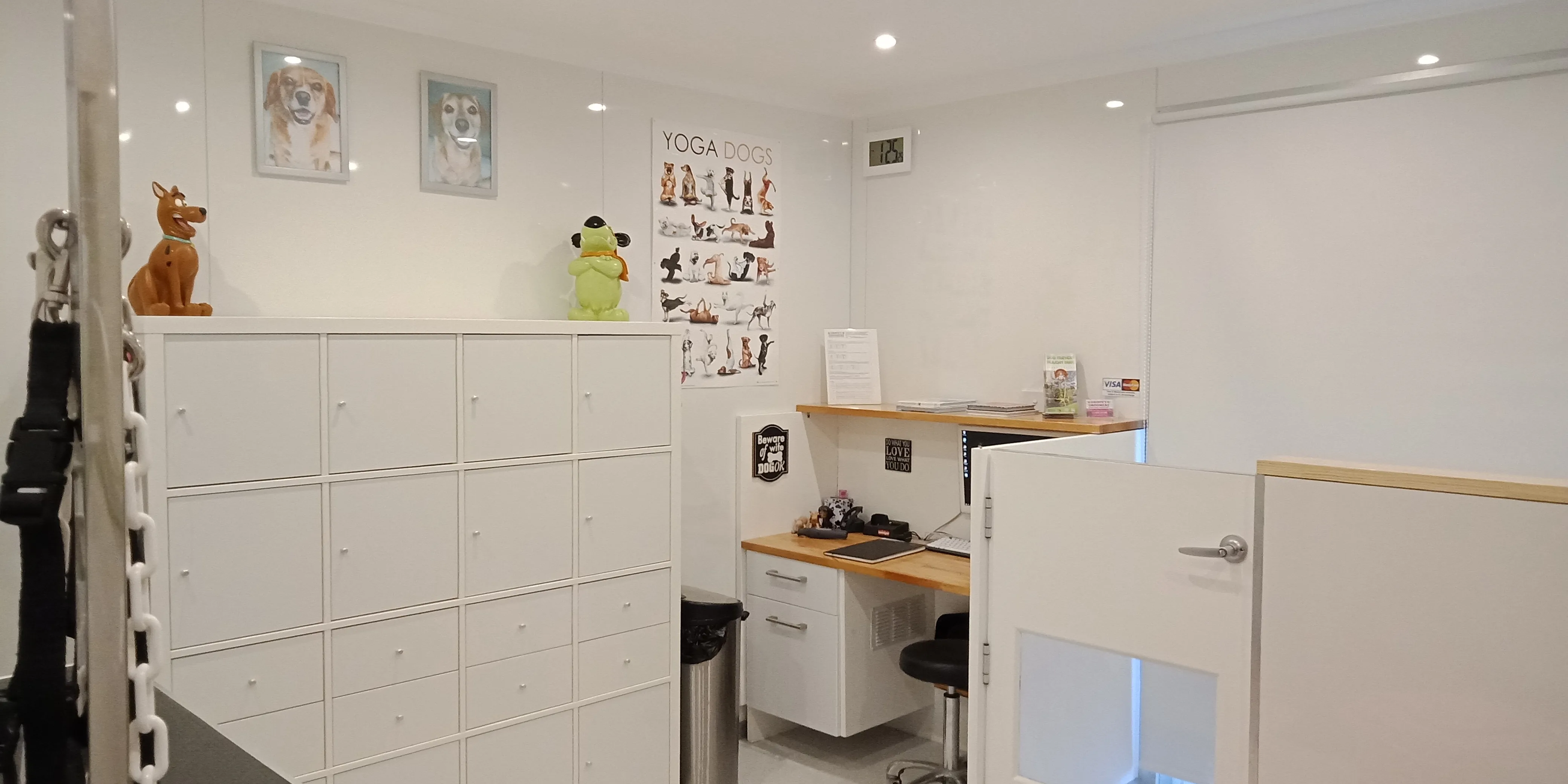 The reception area &mdash; white storage cubbies, Scooby and frog figurines, Yoga Dogs poster, computer desk